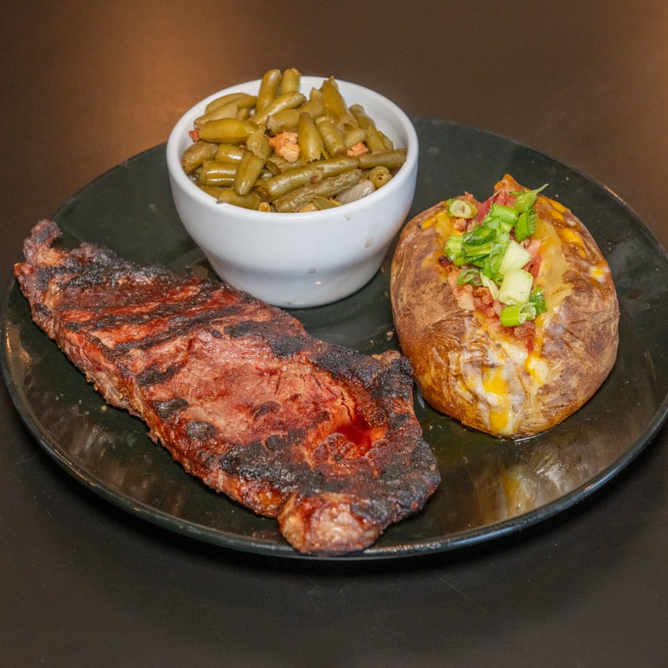 Steak dinner with loaded baked potato.